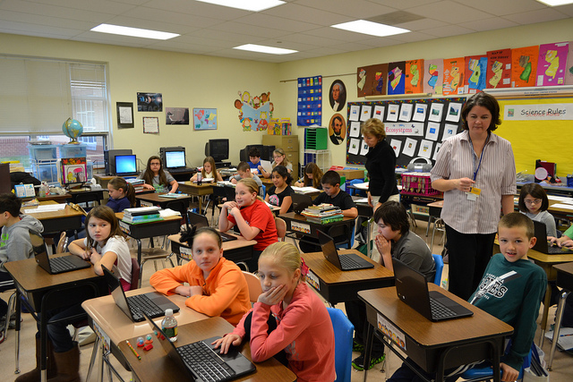 Teacher in classroom with middle school kids and Chromebooks